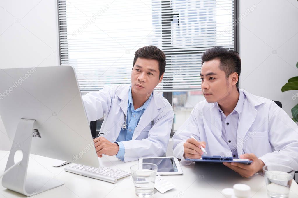 Hardworking doctors reviewing patient's file 