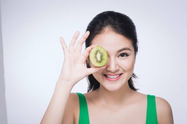 Kivi. Beyaz arka plan üzerinde izole kivi tutan mutlu genç Asyalı kadın