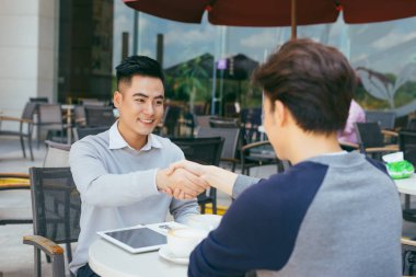 Stokları kontrol. Neşeyle bir toplantıda yerel kafe - görüntü gülümseyen dizüstü bilgisayar üzerinde çalışan iki iş ortakları