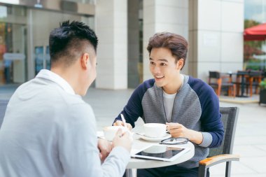Stokları kontrol. Neşeyle bir toplantıda yerel kafe - görüntü gülümseyen dizüstü bilgisayar üzerinde çalışan iki iş ortakları