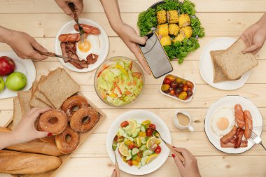 Arkadaşlarınızla akşam yemeği zevk. Grup birlikte ahşap masada otururken yemeğe insan Üstten Görünüm
