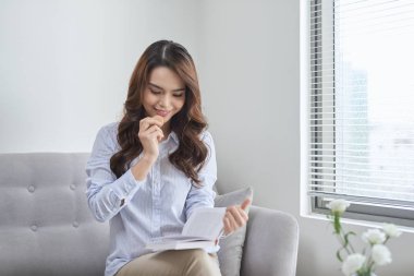 Mutlu kız evde bir kanepede oturan bir acıbadem kurabiyesi yeme 