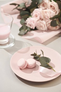 macaroons ile buket pembe Gül çiçek beyaz arka plan üzerinde pastel renklerde. Güzel tatil arka plan. kopya alanı.