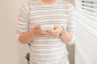 Ofiste onun akıllı telefon kullanan mutlu genç adam