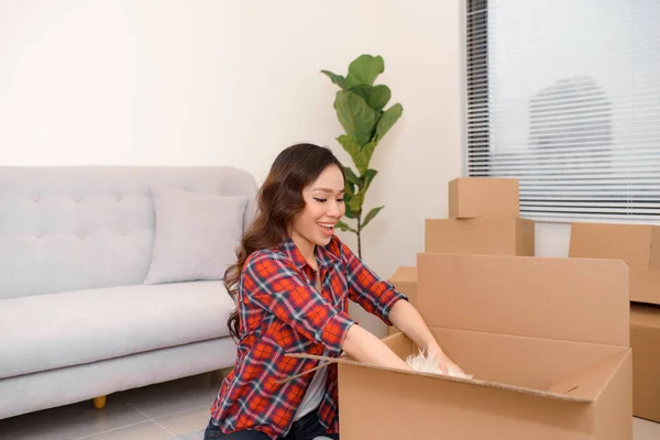 Emocionado joven asiático mujer desembalaje cajas de cartón con acogedor hogar — Foto de Stock
