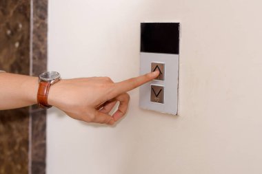 Ok asansör düğmesine kadar iterek kişi.