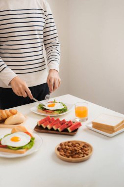 Bıçak ve çatal ile kahvaltı bir adam