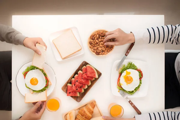 Homens tomando café da manhã com torradas à mesa — Fotografia de Stock