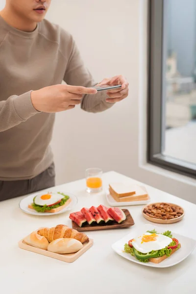 Foto de comida en el teléfono inteligente. Sandwich con huevo escalfado — Foto de Stock