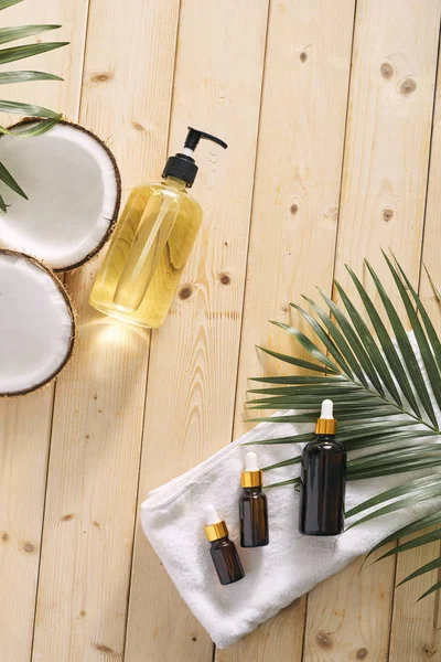 Pęknięty kokos i butelkę oleju na stole - spa, Pielęgnacja skóry — Zdjęcie stockowe