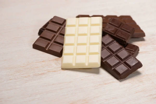 Много разнообразных шоколадных батончиков в коробке на белой деревянной спинке — стоковое фото