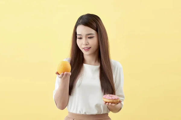 Portrait Smiling Young Asian Woman Choosing Donut Orange Isolated Yellow — Stock Photo, Image