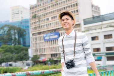 Bavulla seyahat eden gülümseyen genç bir adamın portresi 