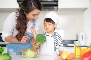 Anne ile kızı mutfakta yemek hazırlama ve birlikte zevk.