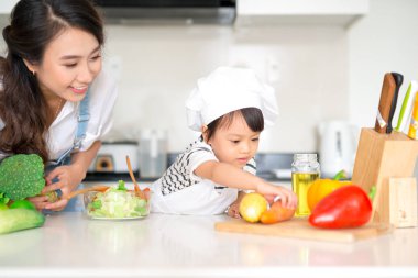 Anne ile kızı mutfakta yemek hazırlama ve birlikte zevk.