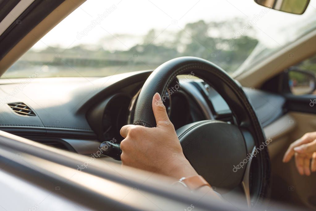 male hands on steering wheel on the right with country side view