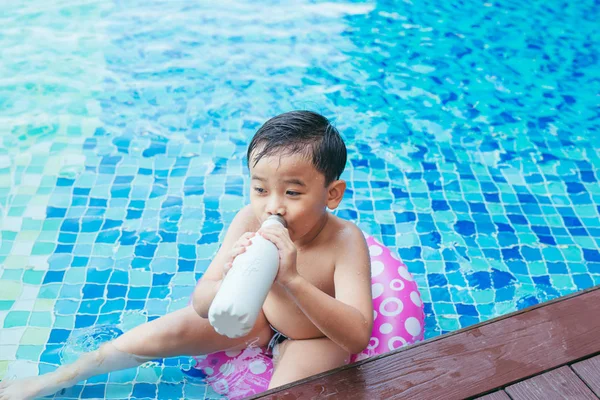 男孩在游泳池喝水 — 图库照片
