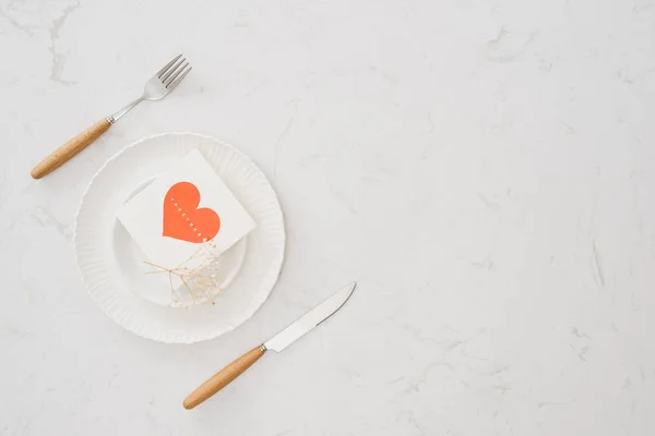 love dinner setting fork and spoon tie with red ribbon on plate on white background , love and romance concept