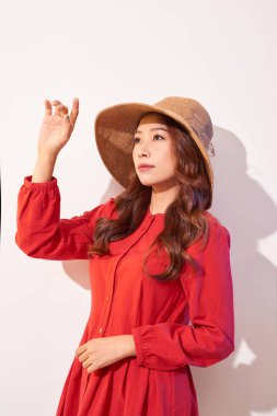 Güneşli bir günde poz geniş gülümseme mutlu kadınla. Gülen kız kırmızı elbiseler ve hafta sonu güzel havanın tadını trendy hasır şapka.