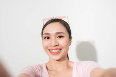 Genç güzel kadın selfie alarak close-up. İzole beyaz arka plan