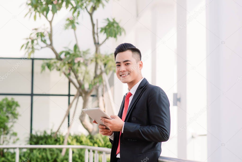 Young Asian Businessman working on tablet, Lifestyle of modern male to communicate, message or use technology in business, Always connected concept, Focus on tablet