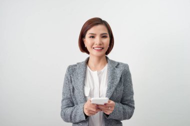 Beyaz arka plan üzerinde Smartphone kullanarak gülümseyen iş kadını.