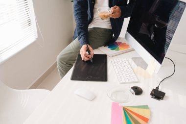 Dijital çizim tabletiyle ofiste çalışan grafik tasarımcı.