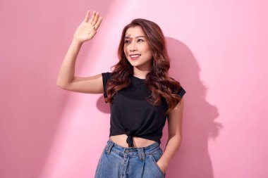 Genç ve güzel Asyalı kadın pembe arka planda izole edilmiş güneş ışığından korkuyor. Yazın cilt bakımı ve güneş ışığından korunma kavramı 