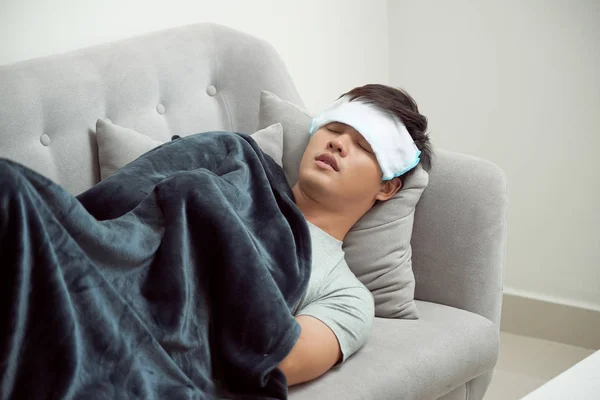 Sick Man Lying Sofa Checking His Temperature Blanket Home Living — Stock Photo, Image