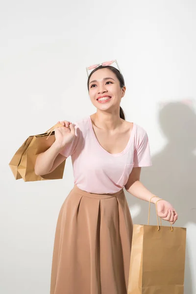 Alışveriş Torbaları Tutan Genç Kadın Gülümseyerek Üzerinde Beyaz Izole Kamera — Stok fotoğraf