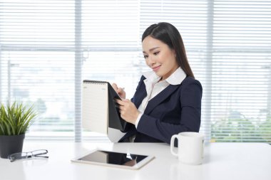 Kadın bir takvim yazma bilgisayar masası üzerinde 