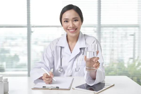 Sorridente Medico Femminile Che Offre Bicchiere Acqua Nel Suo Ufficio — Foto Stock