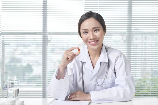 Hospital medical expert doctor shows the pill to take to her patient.