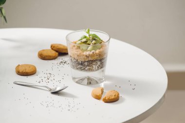 Sağlıklı yemeye hazır besleyici bir kahvaltı - granola badem, chia tohum, muz ve Kivi Meyve ve çilek ile ve süt ile bir kavanoz