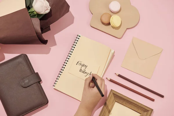 Mano de mujer con bolígrafo escrito en la tarjeta de felicitación sobre la mesa . — Foto de Stock