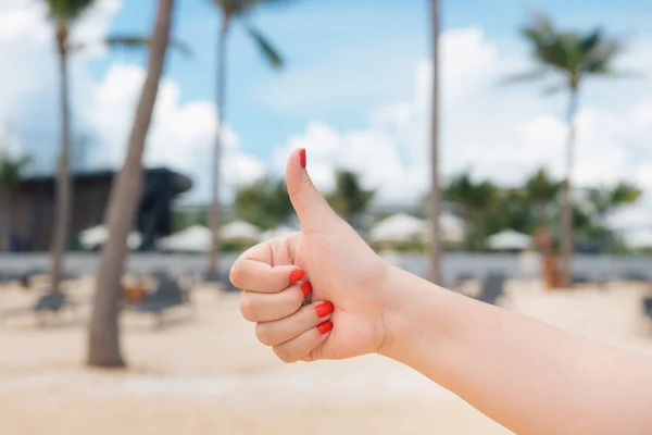 hand thump up on a nice summer holiday beach sea background sunrise sunset