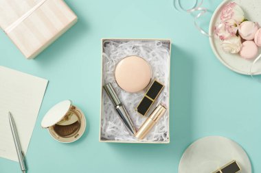 Makyaj ürünleri hediye kutusu üzerinde mavi arka plan ile görüntü 