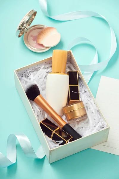 image of make up products with gift box on blue background