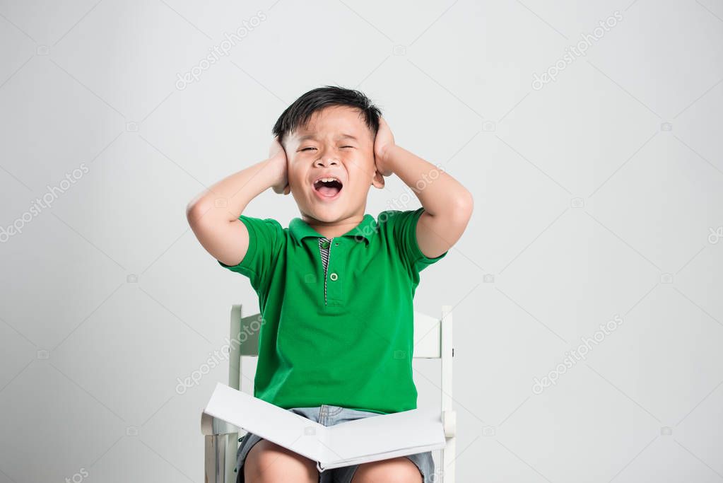 Young boy and closed eyes covering ears with hands