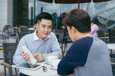 Belge seyir ve Café iken tartışırken iş adamları. Birlikte kahve dükkanında iş raporu üzerinde çalışan iki iş adamları. -Görüntü