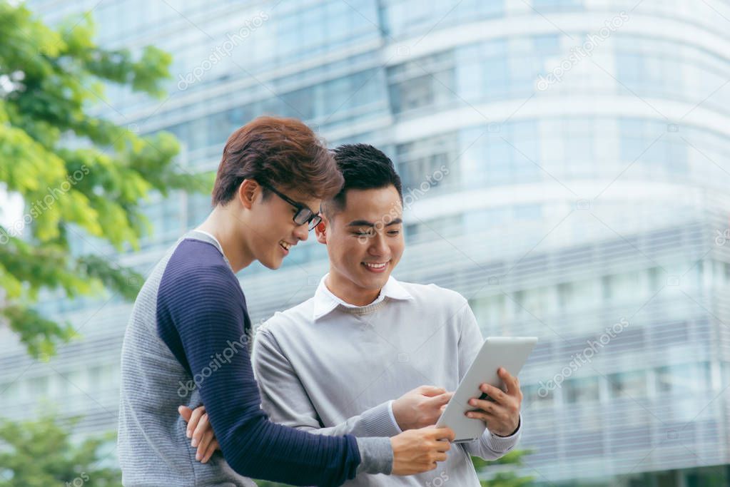 Closeup of Smiling Coworkers Using Tablet Outside - Image