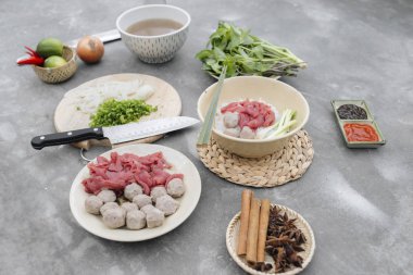 Geleneksel Vietnamca otlar, et, Pirinç Noodle Pho bo çorba suyu. Pho bo chopsticks, kase kaşık. Metin için yer. Üstten Görünüm. Ahşap masa arka plan Asya yemek Pho bo. Vietnamca çorbası