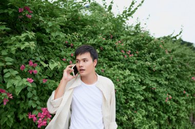 Yakışıklı genç adam sokakta yürürken telefonda konuşurken