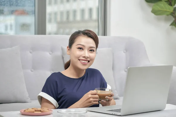 ラップトップ コンピューターや自宅のクレジット カードで床に座って一杯のコーヒーを保持している笑顔の若いアジア女性 — ストック写真