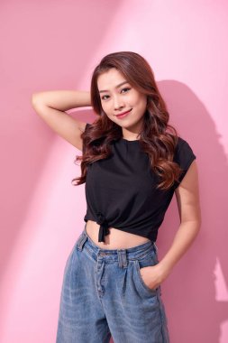 yaşam tarzı, güzellik ve insanlar kavramı: pembe bir arka plan üzerinde genç sevimli gülümseyen kız