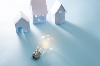 Mavi arka plan üzerinde ampul ile Ev Enerji
