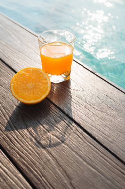 Bir yüzme havuzu etrafında portakal suyu