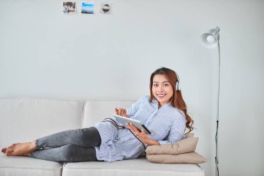 Tablet Asya genç güzel kadın iş müzik kulaklık dinlemek