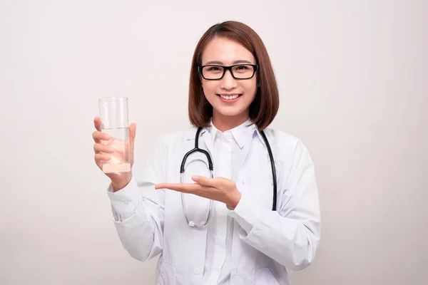 Ung Kvinna Läkare Stående Och Hålla Glas Vatten Över Vit — Stockfoto