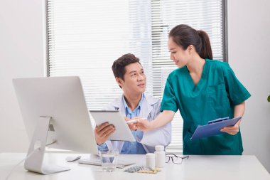 Bir grup doktor ve hemşire hastanın tıbbi raporunu inceliyor. Hastanede hasta dosyası üzerinde birlikte çalışan doktorlardan oluşan ekip.